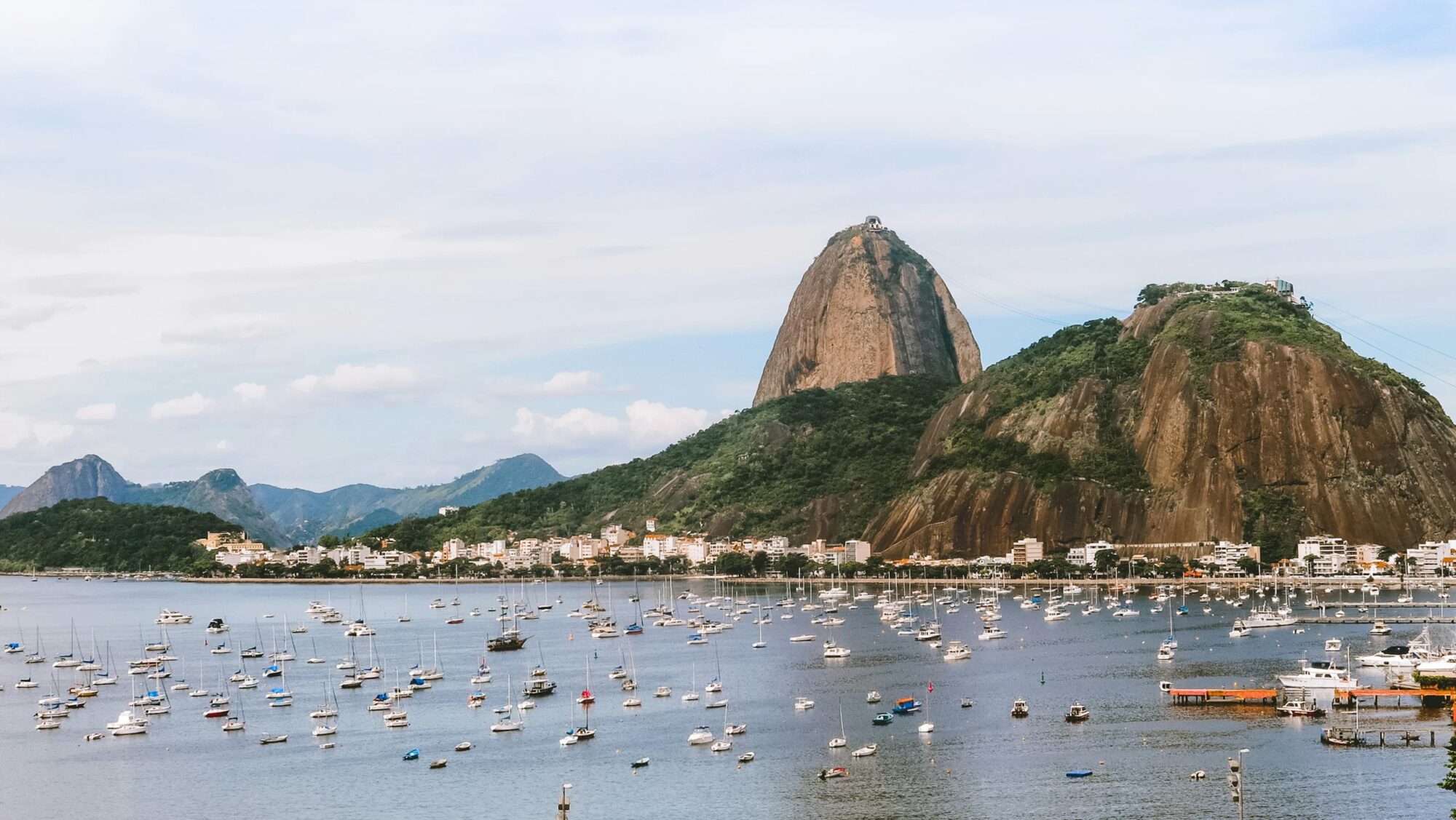 Captivating view of Sugarloaf Mountain in Rio de Janeiro with boats in the bay under a clear sky.