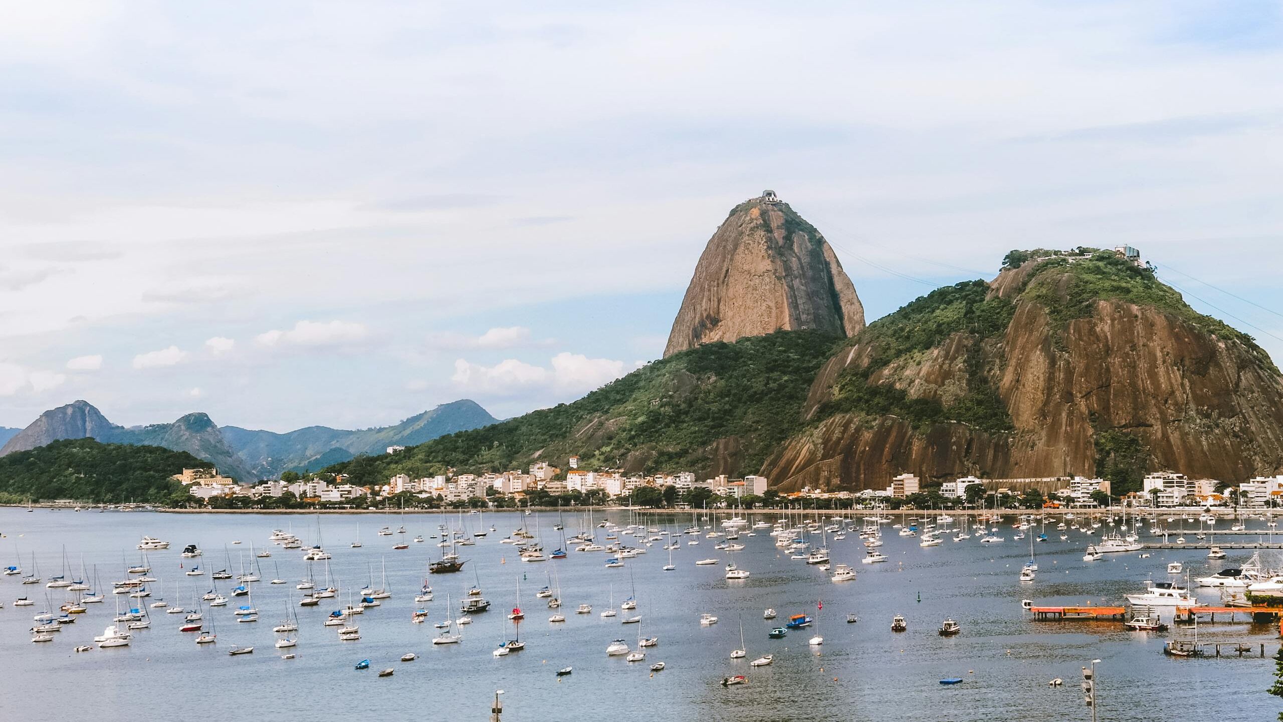 Captivating view of Sugarloaf Mountain in Rio de Janeiro with boats in the bay under a clear sky.